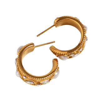 Gold hoop earrings with intricate designs on a white background