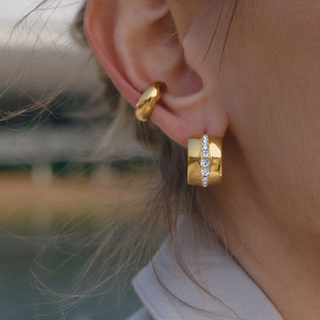 Wide gold huggie hoop earring with a central row of clear stones, shown with a smaller plain hoop; 18K Gold Water-Resistant