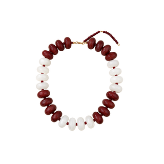 A beaded necklace featuring alternating rows of glossy dark red and smooth white oval beads, with a small gold clasp and red cord at the top, shown on a plain white background.