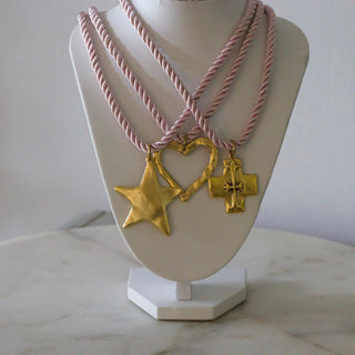 Necklace with gold charms on a mannequin bust against a white background