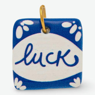 Handcrafted ceramic luck charm with blue floral design and stainless steel jump ring