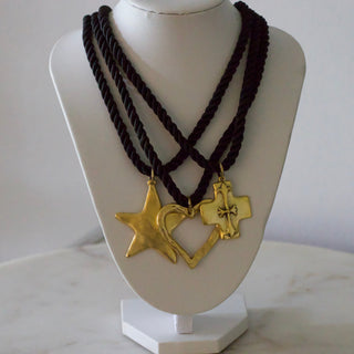 Necklace with gold charms on a mannequin bust against a white background