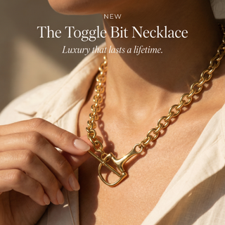 Gold necklace with toggle clasp worn by a person, with text 'NEW The Toggle Bit Necklace Luxury that lasts a lifetime.'