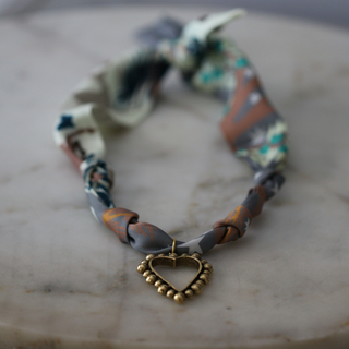 Beaded Heart Scarf Necklace with a twisted multicolour patterned fabric cord and a gold-tone heart pendant edged with beads