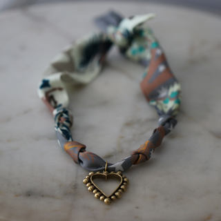 Beaded Heart Scarf Necklace with a patterned fabric band in muted teal, rust and cream, and a gold-tone beaded heart pendant