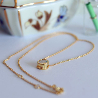 Bezeled CZ Pendant necklace in gold-tone metal with a delicate chain and a cylindrical bezel-set clear stone charm
