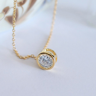 Bezeled CZ Pendant necklace in gold-tone metal with a clear round solitaire stone and delicate chain