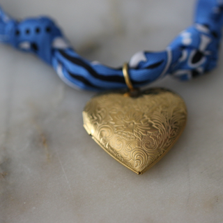 Blue Skies Heart Locket scarf necklace with a twisted blue patterned fabric cord and ornate gold-tone heart pendant