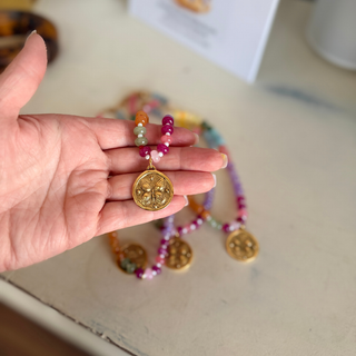 Butterfly Kisses Beaded Necklace with glossy multicolor resin beads and a round gold-tone butterfly medallion