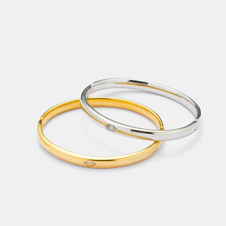 Center Stone Bangle Bracelet in gold and silver stainless steel, with slim polished bands and small clear center stones.