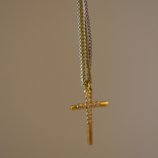 Dual Cross Necklace with a gold-tone chain and slender gold cross pendant accented by small clear stones