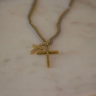 Dual Cross Necklace with layered gold and silver-tone chains, featuring a textured gold cross and a smaller beaded cross pendant.