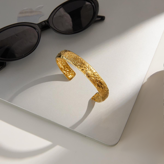 Flora Floral Cuff Bracelet in gold-tone metal with ornate embossed floral patterns and an open adjustable cuff design