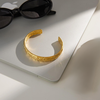 Flora Floral Cuff Bracelet in textured gold-tone metal, with an open adjustable design and embossed floral detailing
