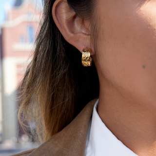 Flora Floral Hoop Earrings in gold-tone metal with raised embossed floral detailing and a chunky curved hoop shape