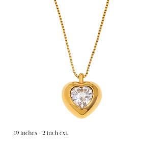 Gold Heart Crystal Necklace with a polished gold heart pendant framing a clear faceted heart-shaped crystal on a fine chain.