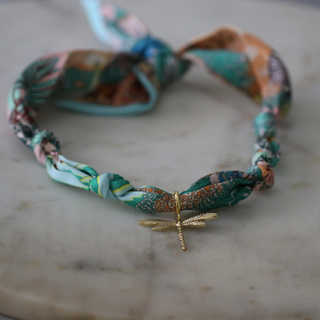 Golden Dawn Dragonfly scarf necklace with a twisted teal and multicoloured patterned fabric band and gold-tone dragonfly charm
