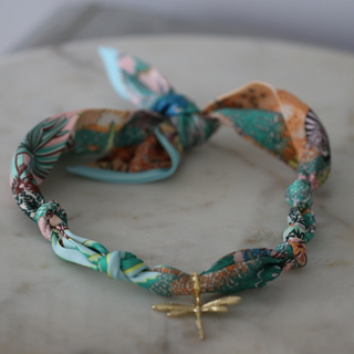 Golden Dawn Dragonfly scarf necklace in teal, turquoise, and rust patterned fabric with a small gold-tone dragonfly pendant