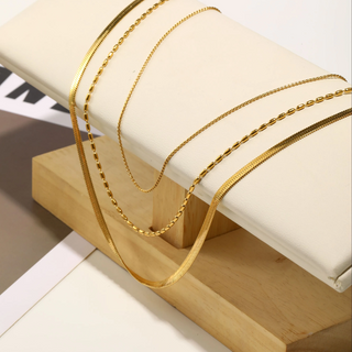 Golden Layers Triple Necklace in gold-tone metal, featuring three delicate chains with varied link patterns for a layered look