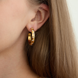 Harlow Crystal Hoop Earrings in polished gold-tone metal, set with clear stones along a sleek open hoop design