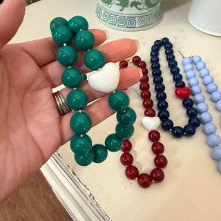 Hartley Heart Statement Necklace in glossy green acrylic beads with a white acrylic heart accent and gold-tone spacers.