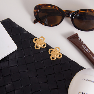 Laurel Knot Earrings in gold-tone metal, featuring matching sculptural interlocking knots with textured detailing