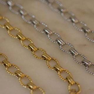 Laurel Link Bracelet in gold and silver-toned metal, featuring polished oval links joined by twisted rope-style loops