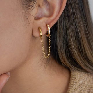 Linked Huggie Hoop Earrings in gold-tone metal, with one polished hoop, one crystal-studded hoop and a delicate chain