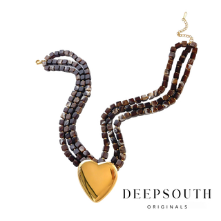 Marlowe Heart Necklace with rich brown square beads, polished gold heart centerpiece, and gold-tone spacer accents in a multi-strand design.