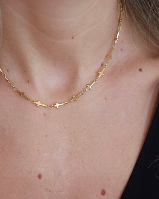 Mini Cross Necklace in gold-tone metal with a delicate fine chain and small cross charms spaced along its length