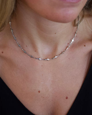 Mini Cross Necklace in silver-toned metal with a fine chain and evenly spaced small cross charms