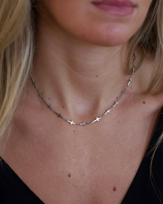 Mini Cross Necklace in silver-tone metal, featuring a fine chain decorated with small cross-shaped links worn close to the neck