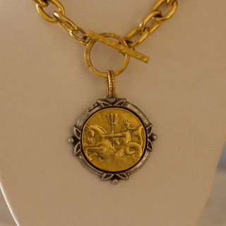 Neptune Coin Necklace with a round gold-tone coin pendant, textured silver-tone edging, and chunky gold chain