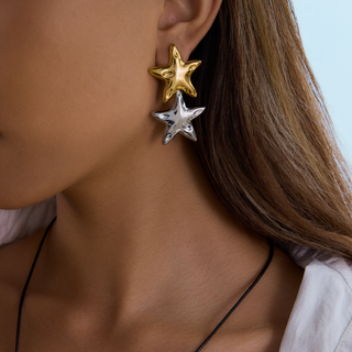 Riviera Star Earrings with glossy gold and silver star charms, stacked together as playful mixed-metal dangles.