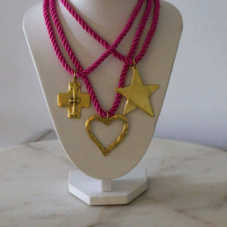 Silk Cord Pendant Necklace with magenta twisted cords and three gold-tone pendants: a cross, star, and heart
