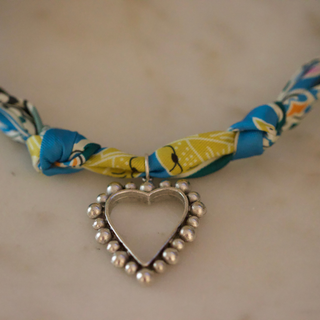 Silver Heart Scarf Necklace with a blue, yellow, and white patterned fabric scarf and an open heart pendant edged with silver beads