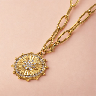 Sunburst Necklace in gold-tone metal with a round ridged sunburst medallion, clear stones, and a chunky oval-link chain