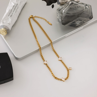 Torino star curb chain necklace in gold-tone metal with a fine curb chain and spaced square clear stone accents