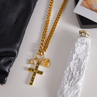 Trinity Necklace with chunky gold-tone chain and cross, heart, and starburst charms in polished metal