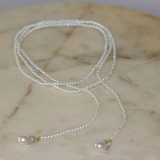 Wrap Pearl Lariat Necklace with delicate white glass pearls, gold-tone accents, and two pearl drop ends on a long strand